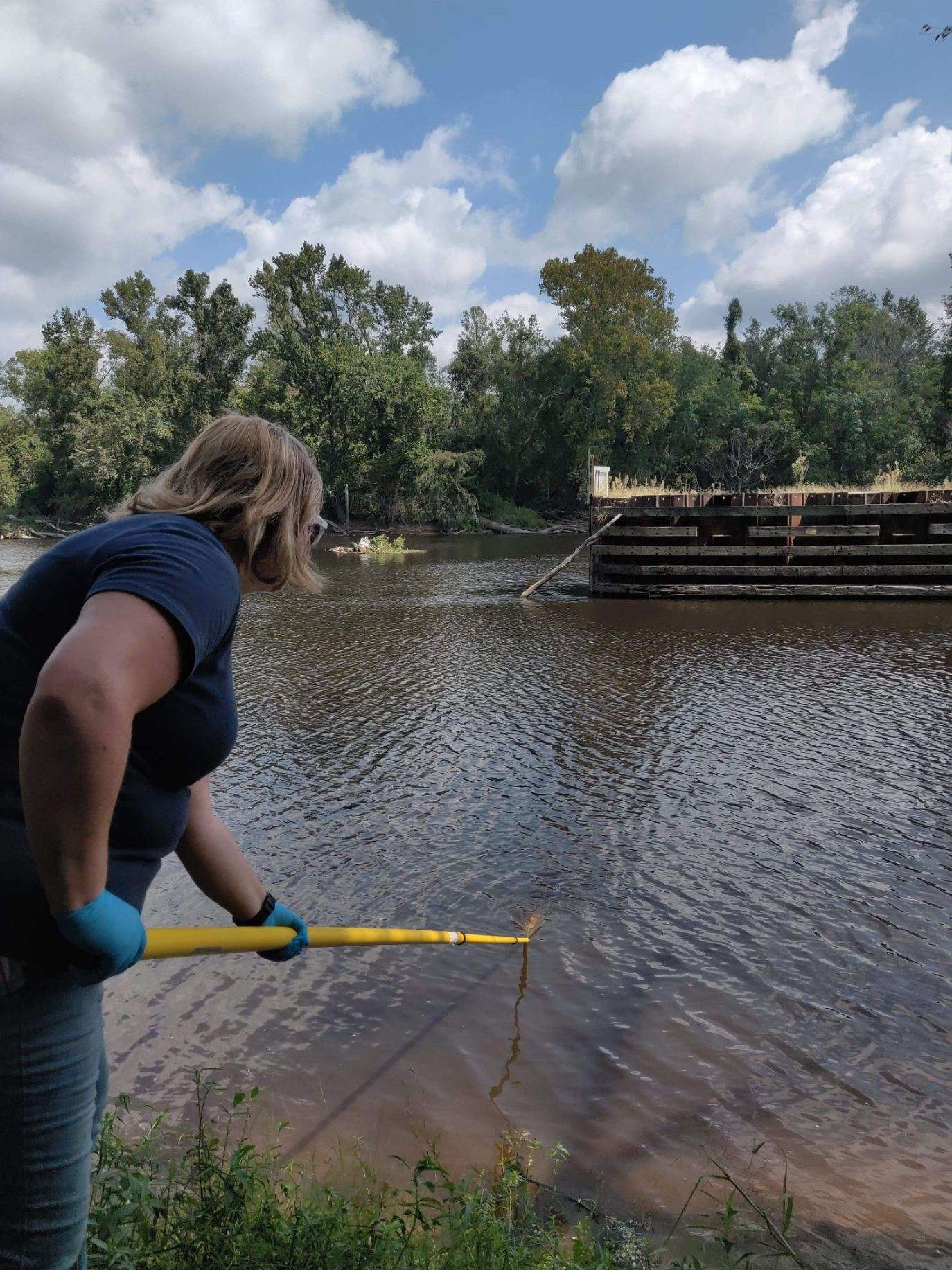 Elizabeth A. Severt, CFPUA Environmental Program Manager, grabs a sample of Cape Fear River Water.